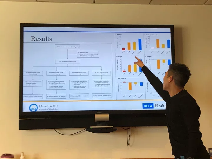 Man presenting powerpoint for Research Committee