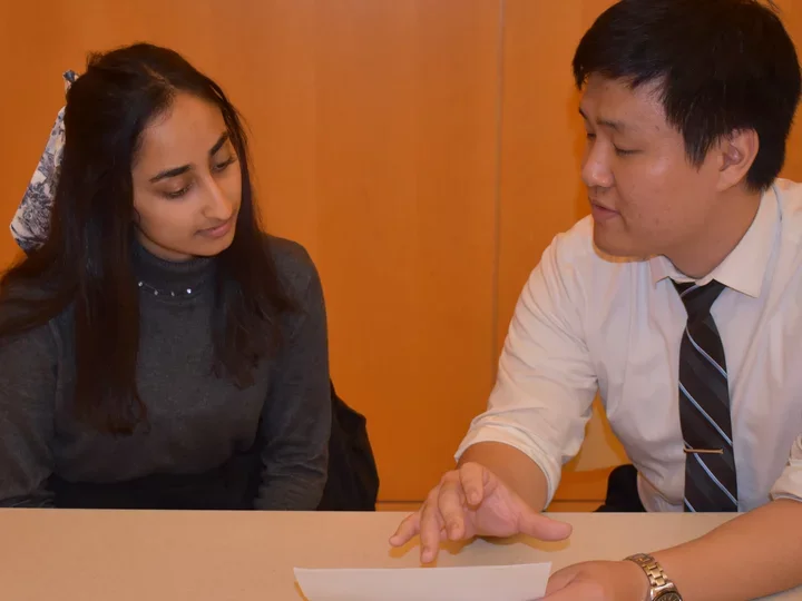 Two members of the Mentorship Committee talking at table