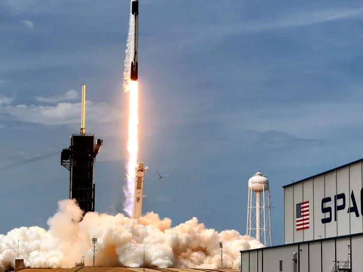 Rocket launching into the sky, with flames and smoke visible at the base as it lifts off