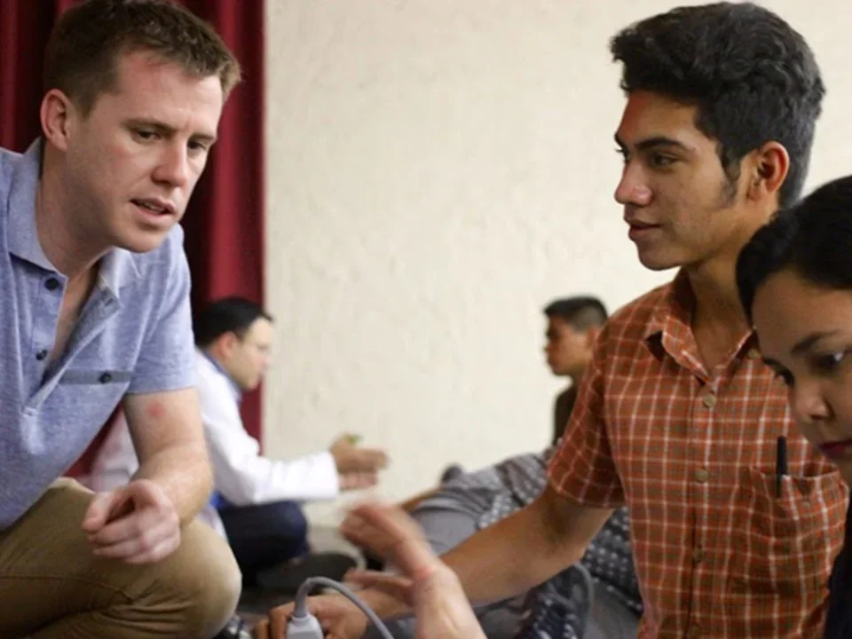 Three individuals engaged in a hands-on medical training activity.