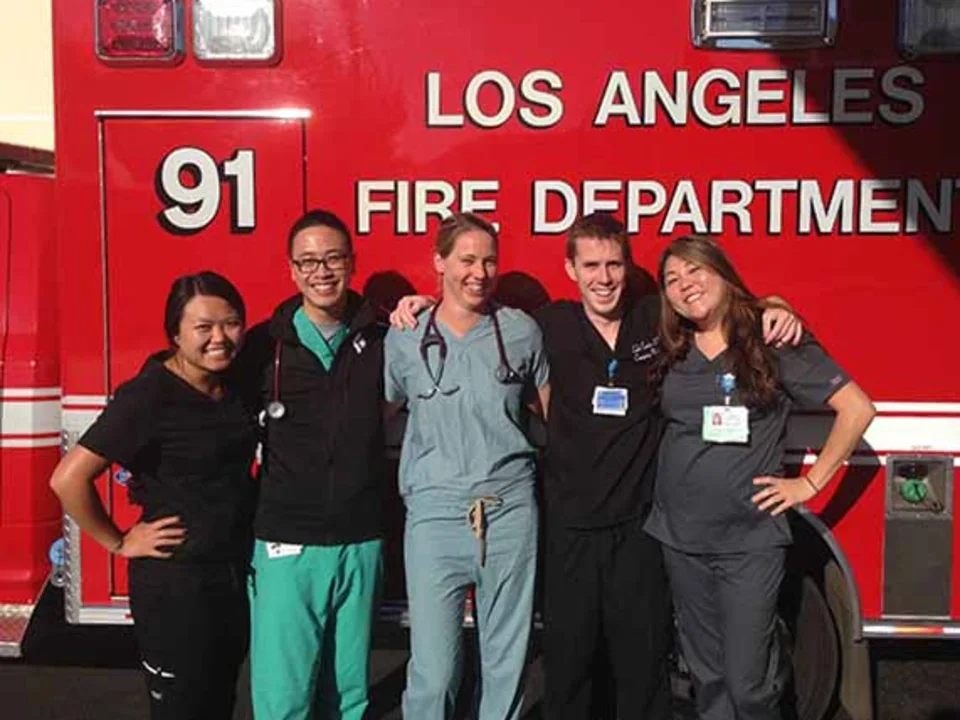 A group of five people, consisting of emergency medical staff, standing in front of a Los Angeles Fire Department ambulance.