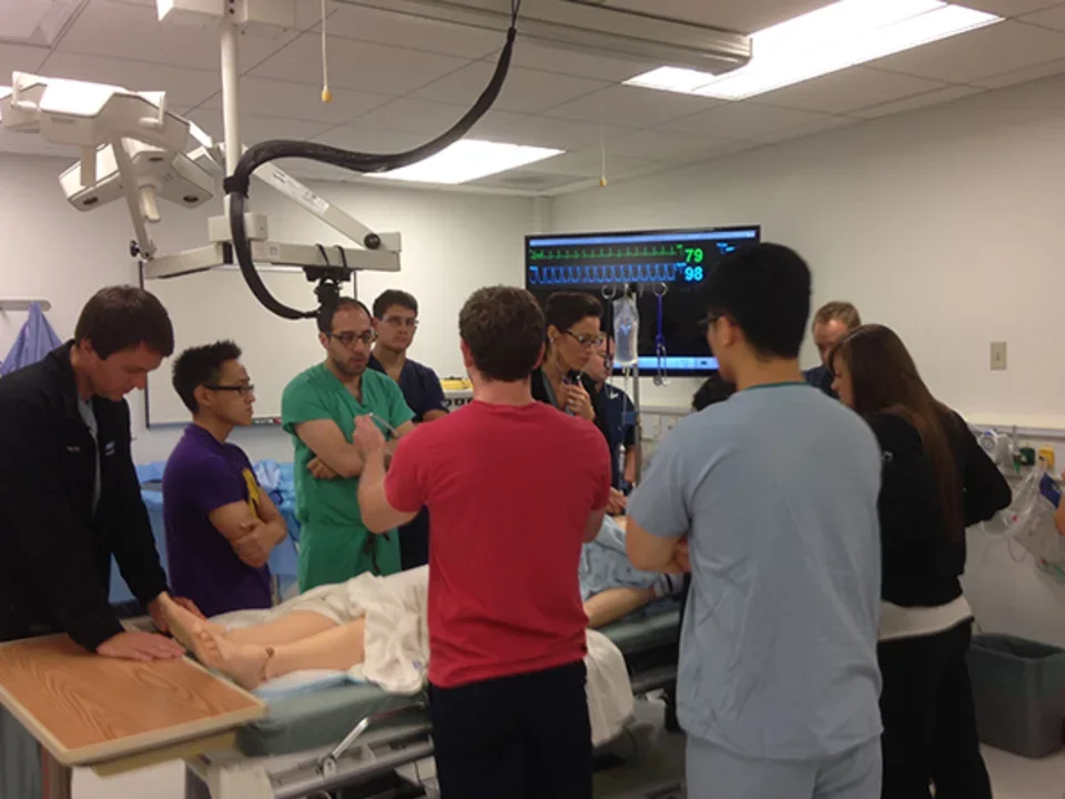 A group of medical professionals gathered around a hospital bed for simulation