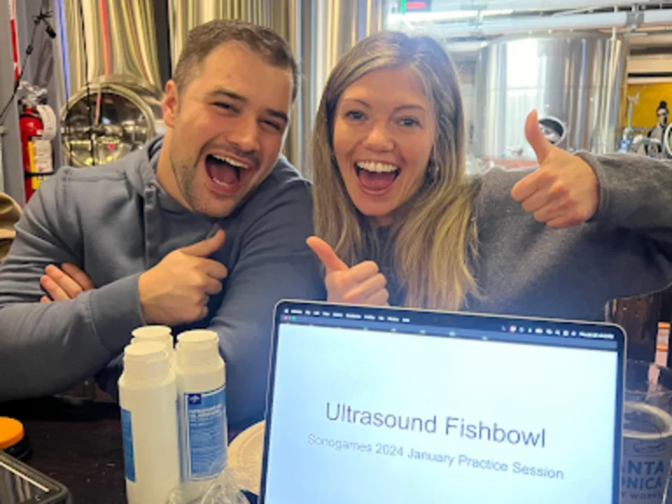 Drs. Sholder and Bass (2026) practice ultrasound for the upcoming SonoGames at a local brewery