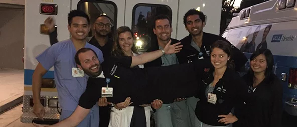 A group of medical professionals gathered in front of a UCLA ambulance.